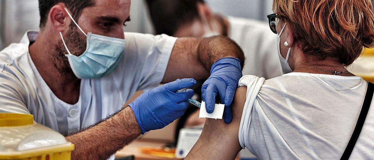 Un sanitario inocula una vacuna a una mujer en el Recinto Ferial de Santa Cruz de Tenerife  | | MARÍA PISACA