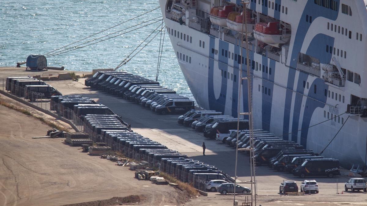 Furgonetas de la Policía Nacional, ante un barco atracado en el puerto de Barcelona para alojar a policías y guardias civiles