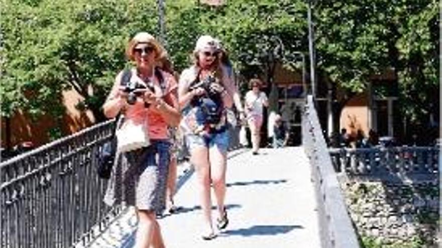 Un grup de visitants passejant pel pont d&#039;en Gómez de Girona.