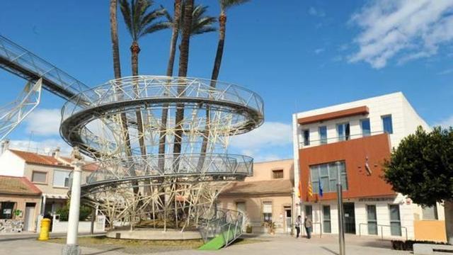El Ayuntamiento de Daya Vieja, junto a la pasarela que se construyó bordeando cinco palmeras singulares.
