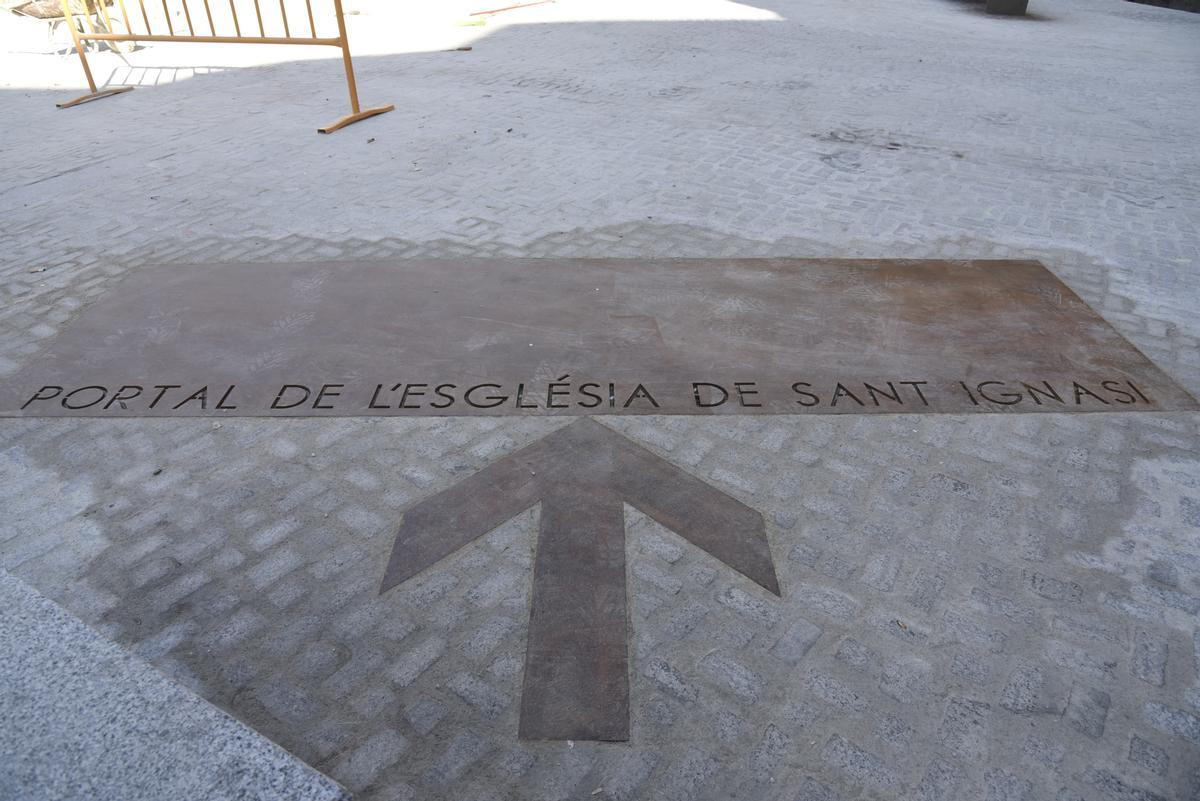 La placa de ferro envellit que senyalitza el portal de l'antiga església