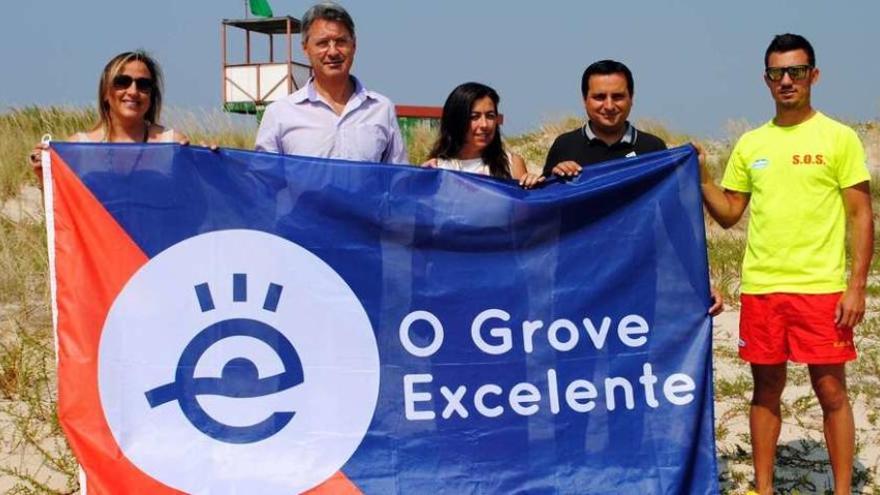 Representantes del gobierno y los socorristas en el izado de la nueva bandera de calidad y diferenciación: &quot;O Grove Excelente&quot;. // Muñiz