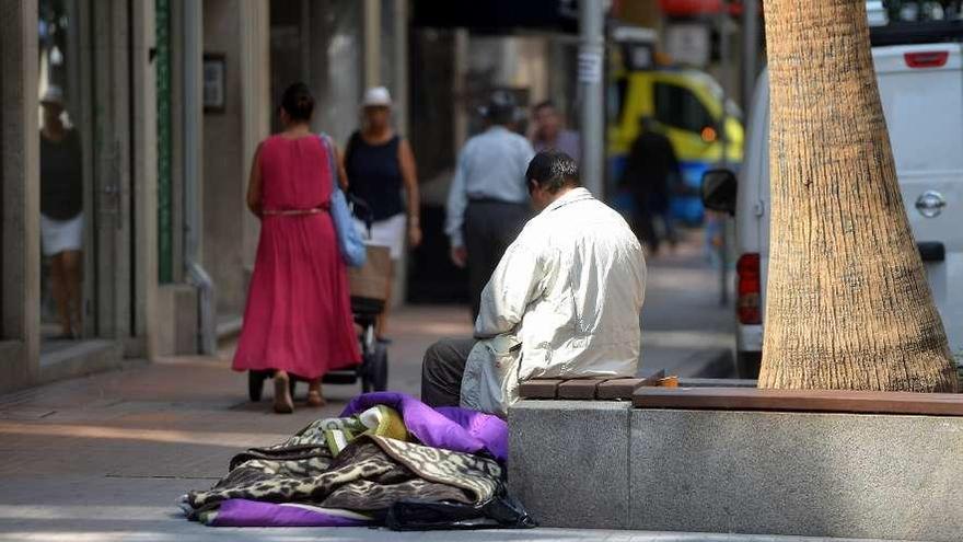 Un hombre pide limosna en la calle.