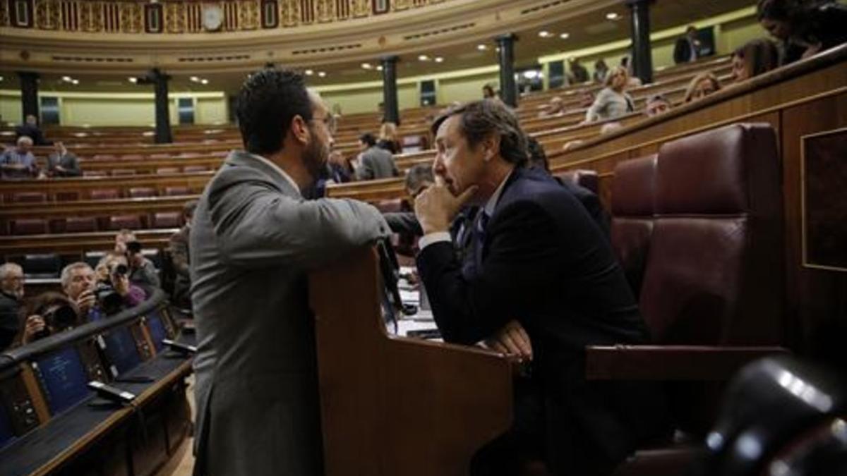 El socialista Antonio Hernando (izquierda) y el popular Rafael Hernando conversan en el hemiciclo del Congreso.