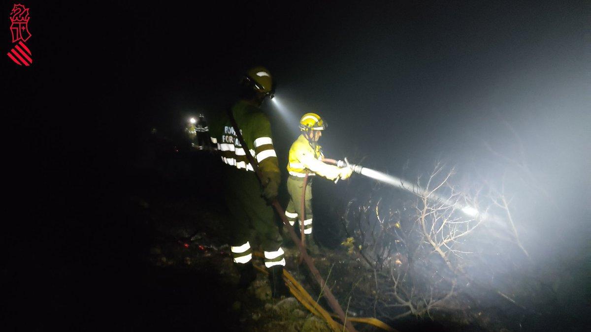 Imagen de los bomberos sofocando las llamas esta noche en Les Coves de Vinromà.
