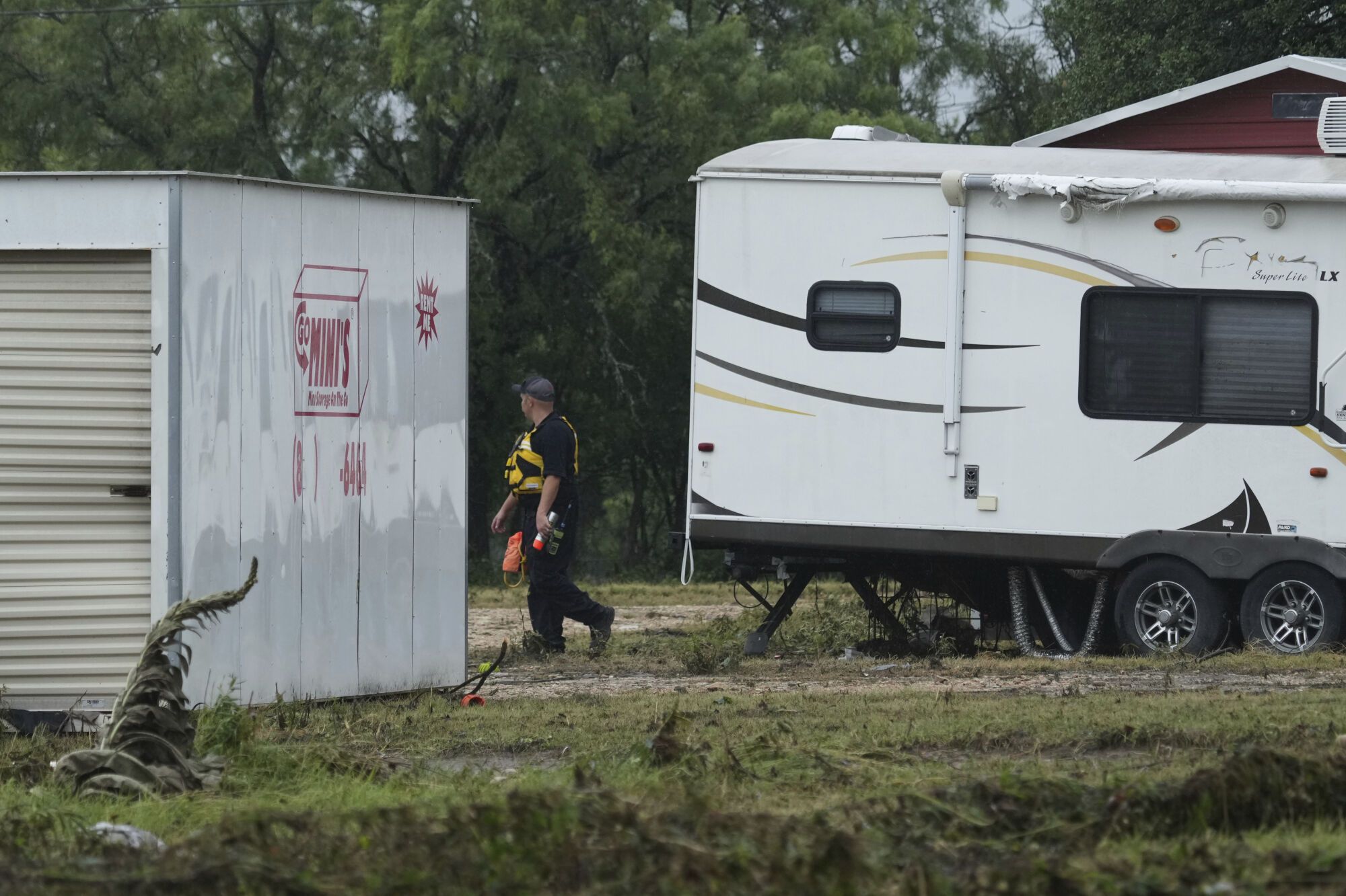 A first responder searches an area along the Guadalupe River that was hit by flash flooding, Friday, July 4, 2025, in Kerrville, Texas. (AP Photo/Eric Gay)