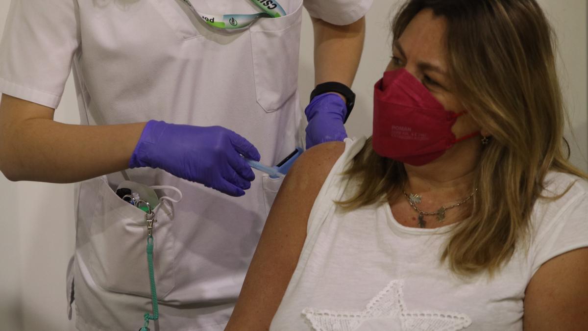 Una sanitaria vacuna a una mujer en Málaga.