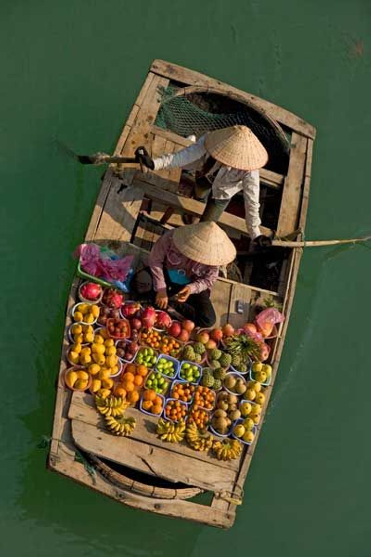 Los vendedores de fruta van de barco en barco por la Bahía de Halong.