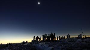 Varias personas observan el eclipse solar de abril de 2024 en el estado de Maine (EEUU)