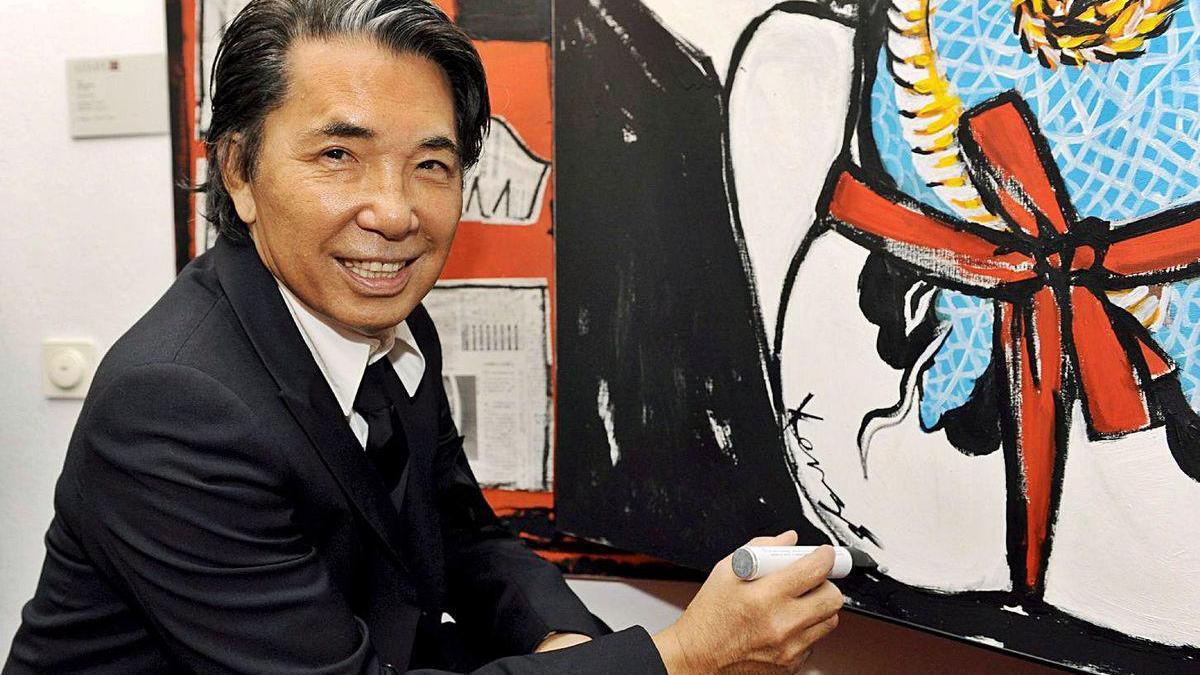 Kenzo Takada alcanzó notoriedad mundial con sus diseños y su marca Kenzo. En la imagen, firma un cuadro suyo.