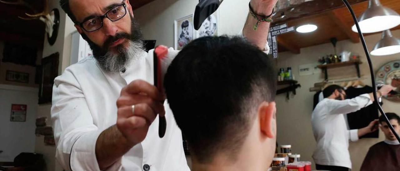 Edu García, atendiendo a un cliente en su barbería hace unos meses.