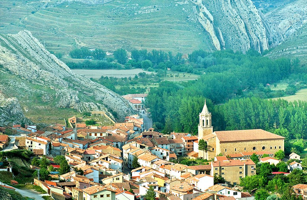 Vista panorámica de Aliaga desde lo alto del entorno de La Porra, con el casco urbano encajado entre montañas.