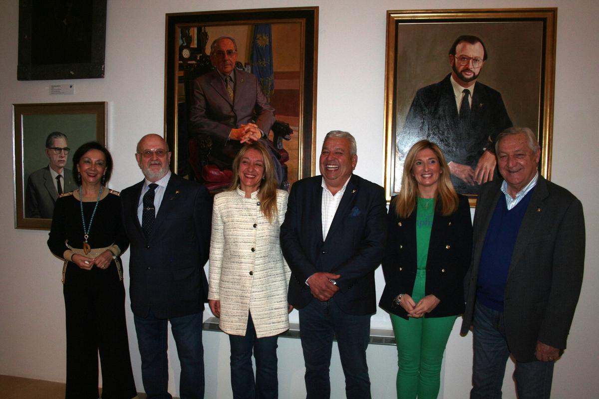 Tana García, Ángel Olcina, María Ángeles Mazuecos, José María Miñarro, María García y Cristóbal Alcolea, ante los retratos de Castillo Navarro y de Olcina.