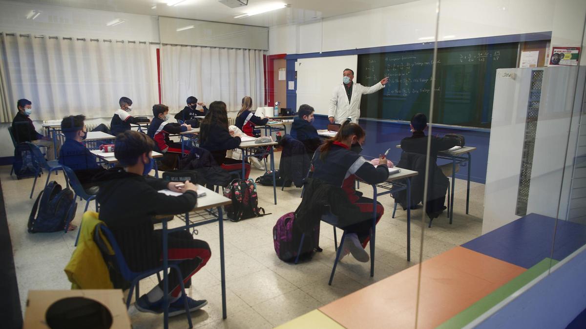 Un profesor imparte clase a los alumnos de un colegio.