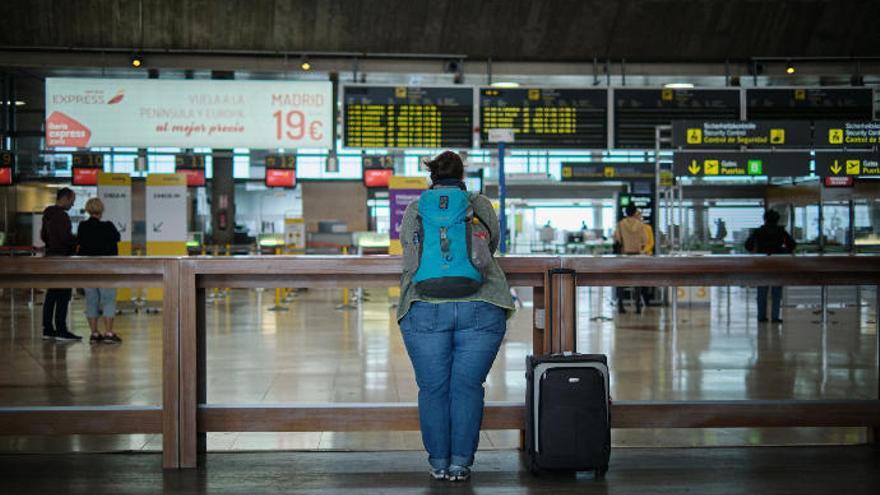 Una joven observa las pantallas de los vuelos en el aeropuerto de Tenerife Norte.