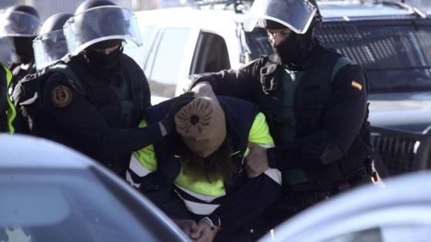 Dos agents introdueixen un dels dos detinguts a Ceuta en un vehicle policial.