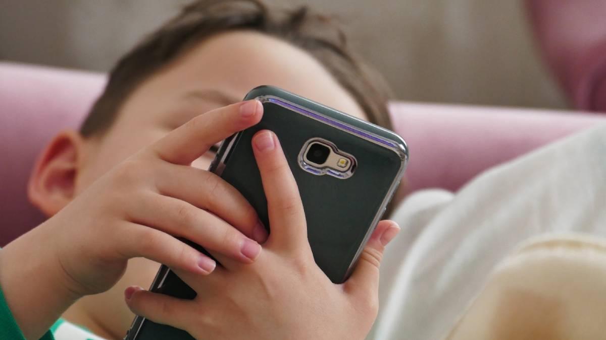 Un niño usando un teléfono móvil.