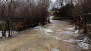 Un puente inundado por el desbordamiento del río Manzanares a su paso por una zona residencial, a 7 de marzo de 2025, en Manzanares el Real, Madrid (España)
