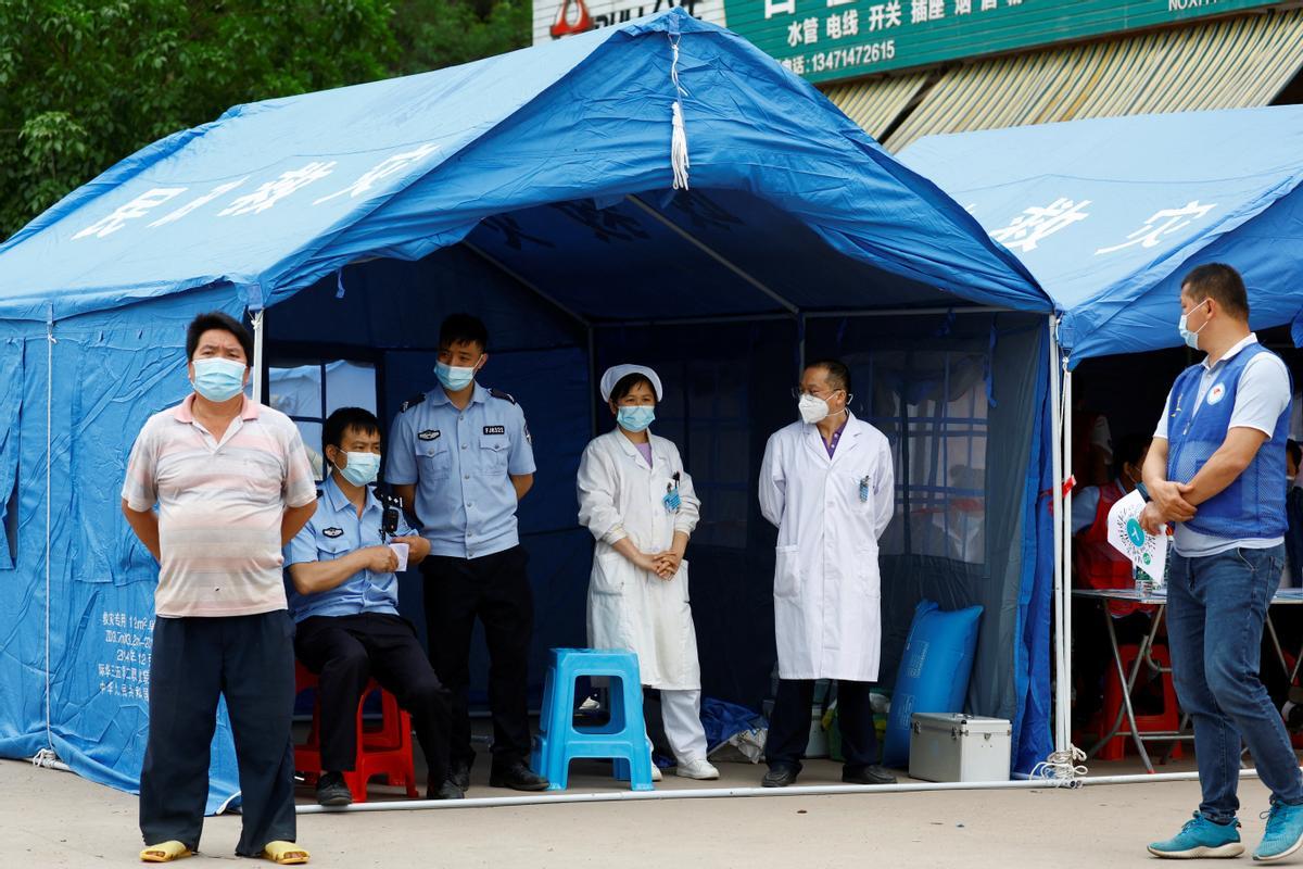 Trabajadores sanitarios y de policía esperan las tareas de rescate tras el accidente del avión Boeing 737-800 de China Eastern, que se estrelló el 21 de marzo en la región de Guangxi