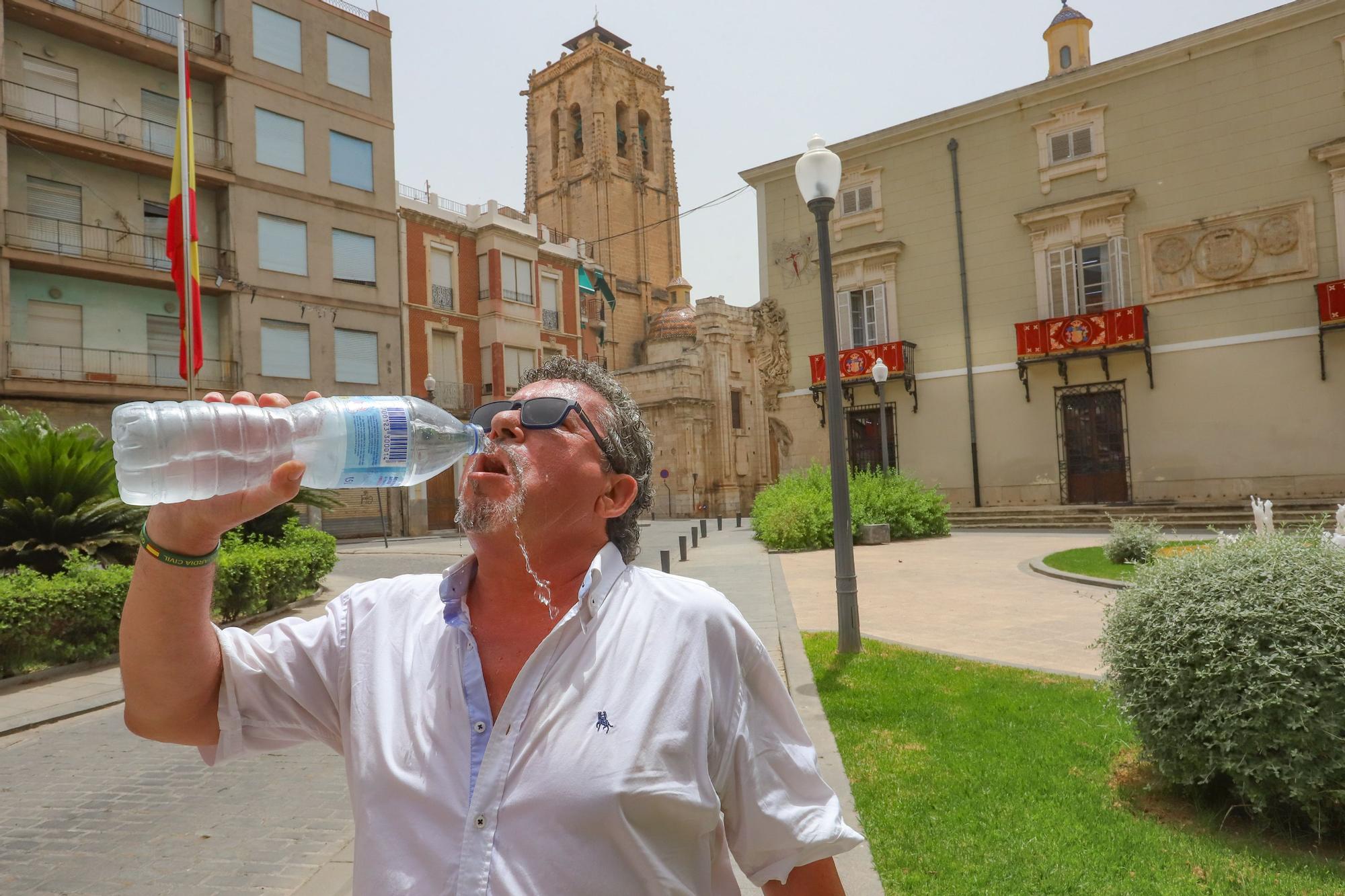 Un ciudadano bebe agua fría para refescarse en Orihuela.