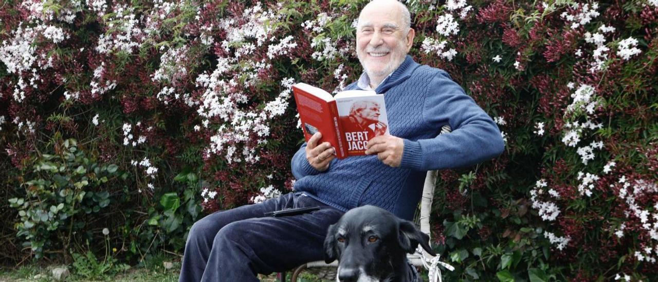 Paulino Tuñón, junto a su perra Deva, ayer, leyendo la biografía de Bert Jacobs en el jardín de su domicilio. | M. León