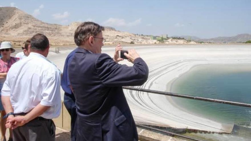 El president Ximo Puig fotografía con su móvil el agua del Júcar que empezó a llenar ayer los embalses de Aspe.