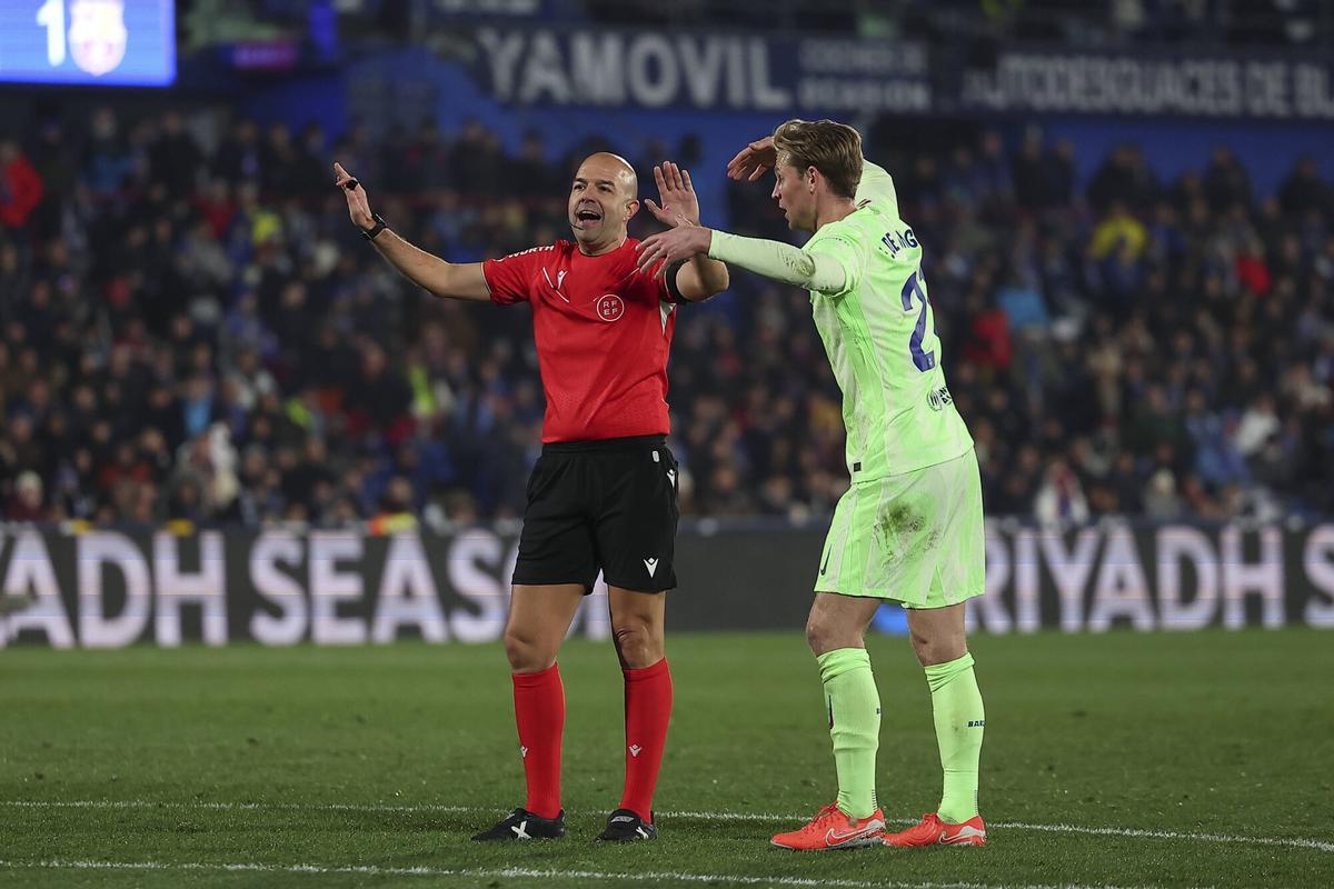 Frenkie de Jong explica a González Fuertes que Koundé ha sido agarrado por Uche en un córner.