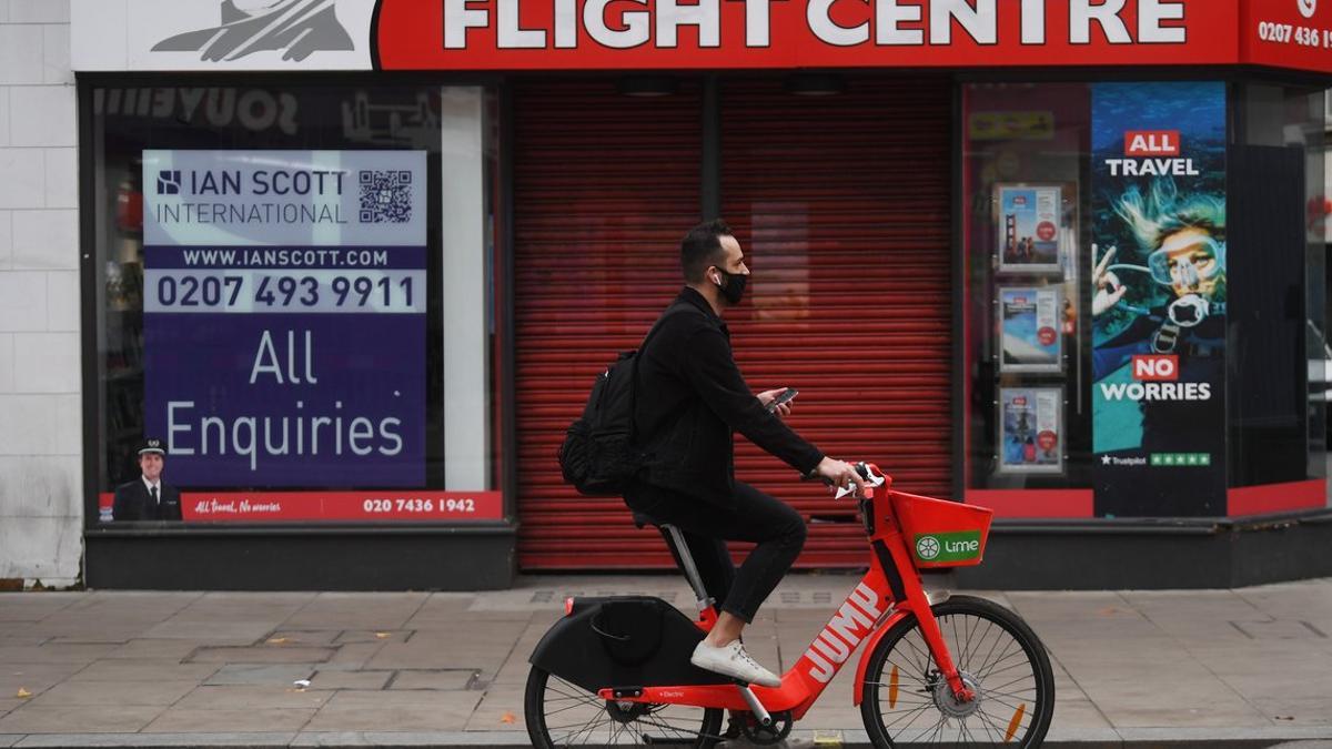 Un ciclista pasa por delante de una agencia de viajes en Londres.