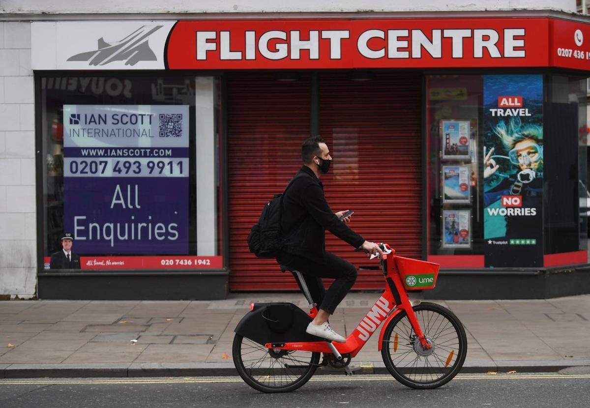 London (United Kingdom), 06/11/2020.- A masked cyclist passes a travel shop on an unusually quiet shopping area of Oxford Street in London, Britain, 06 November 2020. On 05 November 2020 until 02 December 2020 Britain is in lockdown with government advise to stay at home, avoid meeting people you do not live with and to close certain businesses and venues. (Reino Unido, Londres) EFE/EPA/NEIL HALL