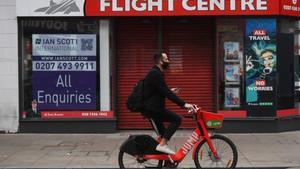 London (United Kingdom), 06/11/2020.- A masked cyclist passes a travel shop on an unusually quiet shopping area of Oxford Street in London, Britain, 06 November 2020. On 05 November 2020 until 02 December 2020 Britain is in lockdown with government advise to stay at home, avoid meeting people you do not live with and to close certain businesses and venues. (Reino Unido, Londres) EFE/EPA/NEIL HALL