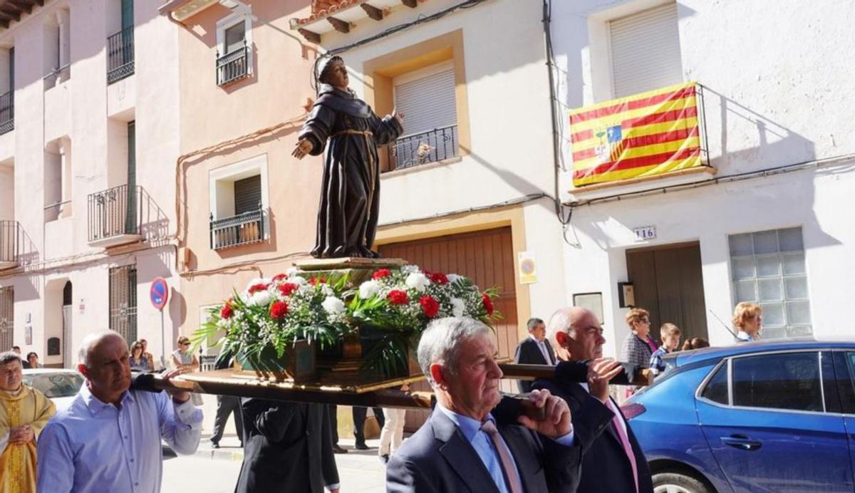 Varios vecinos llevan en procesión la imagen de San Francisco de Asís.