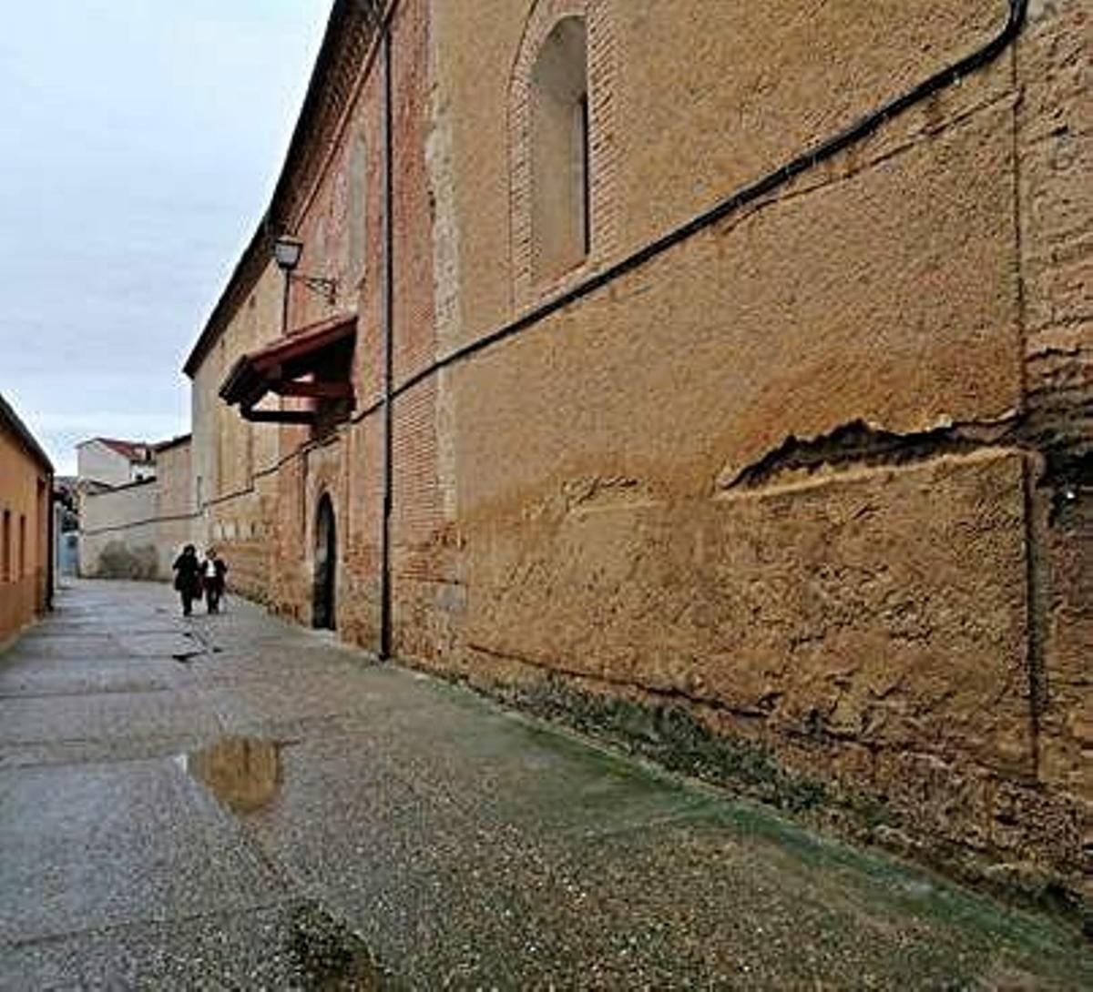 Dos vecinas pasean por la calle Las Monjas en la que se conservan parte de los muros del convento.