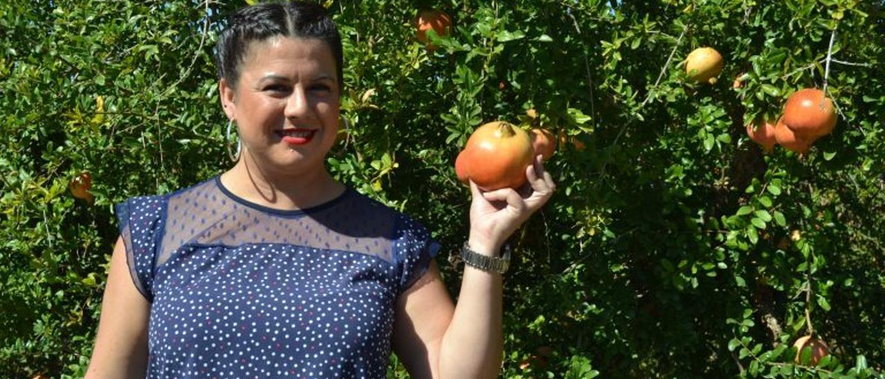La concejala de Amparo Pérez junto a un granado cargado de frutos ya a punto de cosecha