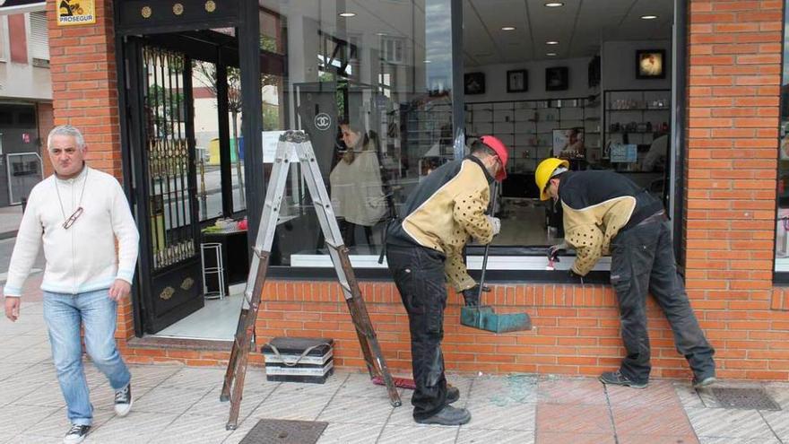 Trabajadores reponiendo la luna del establecimiento en la mañana de ayer.