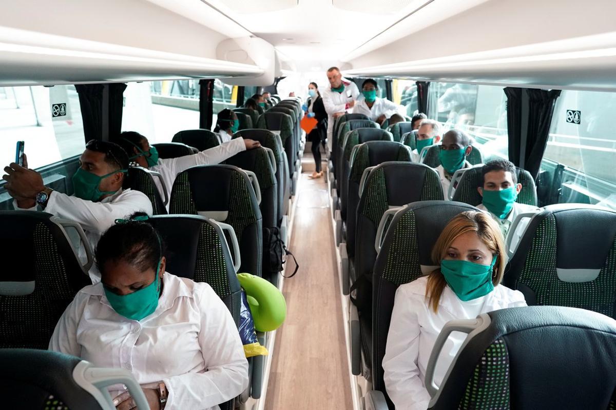 Some of the 39 Cuban doctors are seen inside a bus that will go to Andorra, at Madrid’s Adolfo Suarez Barajas Airport, during the coronavirus disease (COVID-19) outbreak, Spain March 29, 2020. REUTERS/Juan Medina