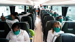 Some of the 39 Cuban doctors are seen inside a bus that will go to Andorra, at Madrid’s Adolfo Suarez Barajas Airport, during the coronavirus disease (COVID-19) outbreak, Spain March 29, 2020. REUTERS/Juan Medina
