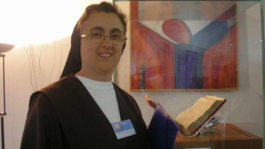 La hermana Pilar Huerta Román posa junto a un antiguo libro.