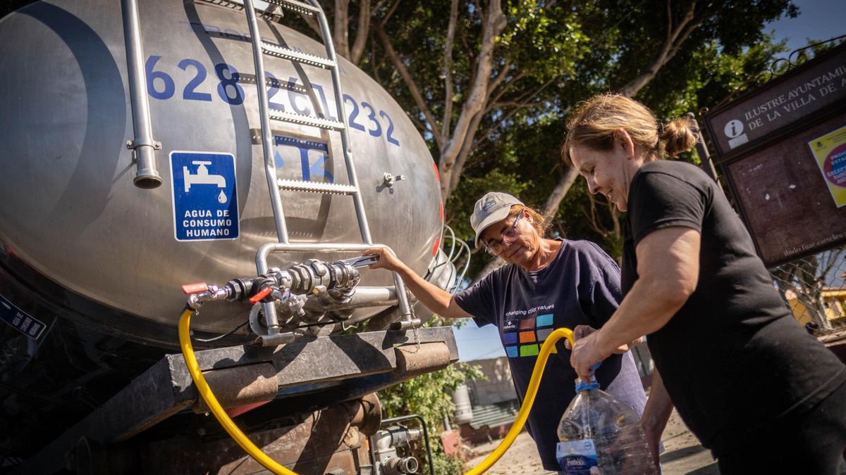 Dos vecinas toman agua de una cuba durante la restricción de beberla del grifo en Arafo el verano pasado