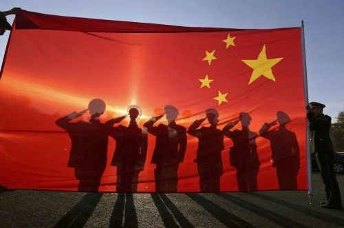 Policías militares, izan diariamente la bandera nacional china y realizan el saludo a la bandera durante una ceremonia en Pekín, 24 de noviembre de 2014.