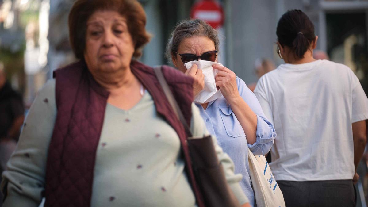 Una mujer se limpia la nariz.