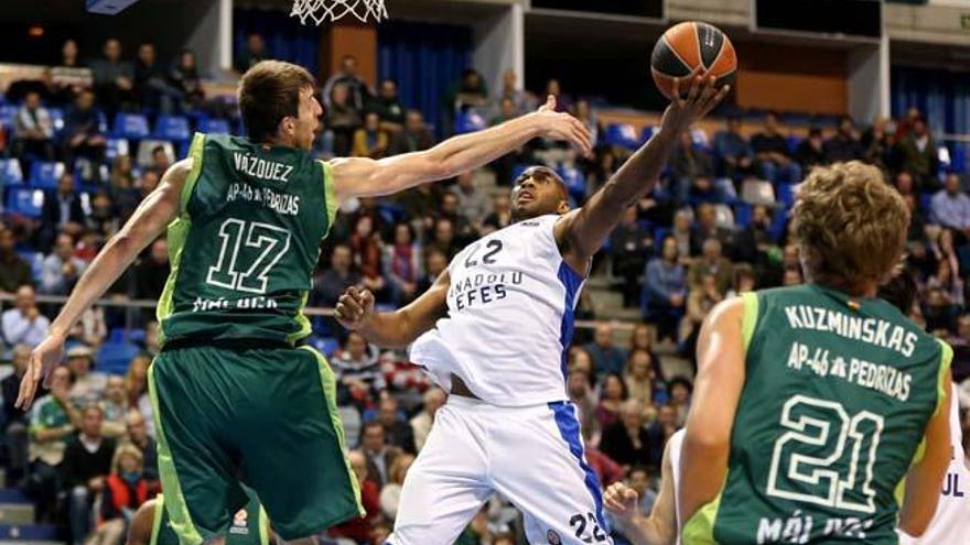 El base estadounidense del Anadolu Efes Jamon Gordon (c) tira a canasta ante el pívot del Unicaja Fran Vázquez (i), durante el partido de baloncesto de la jornada décimo primera de la Clasificación Grupo E Top 16 de la Euroliga, que se disputa hoy el Palacio de Deportes José M Martín Carpena.