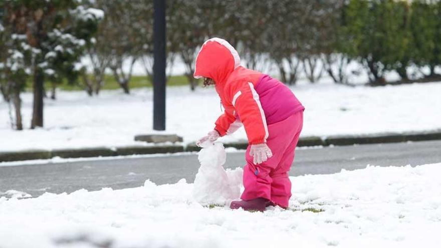 Una niña realiza un muñeco de nieve.