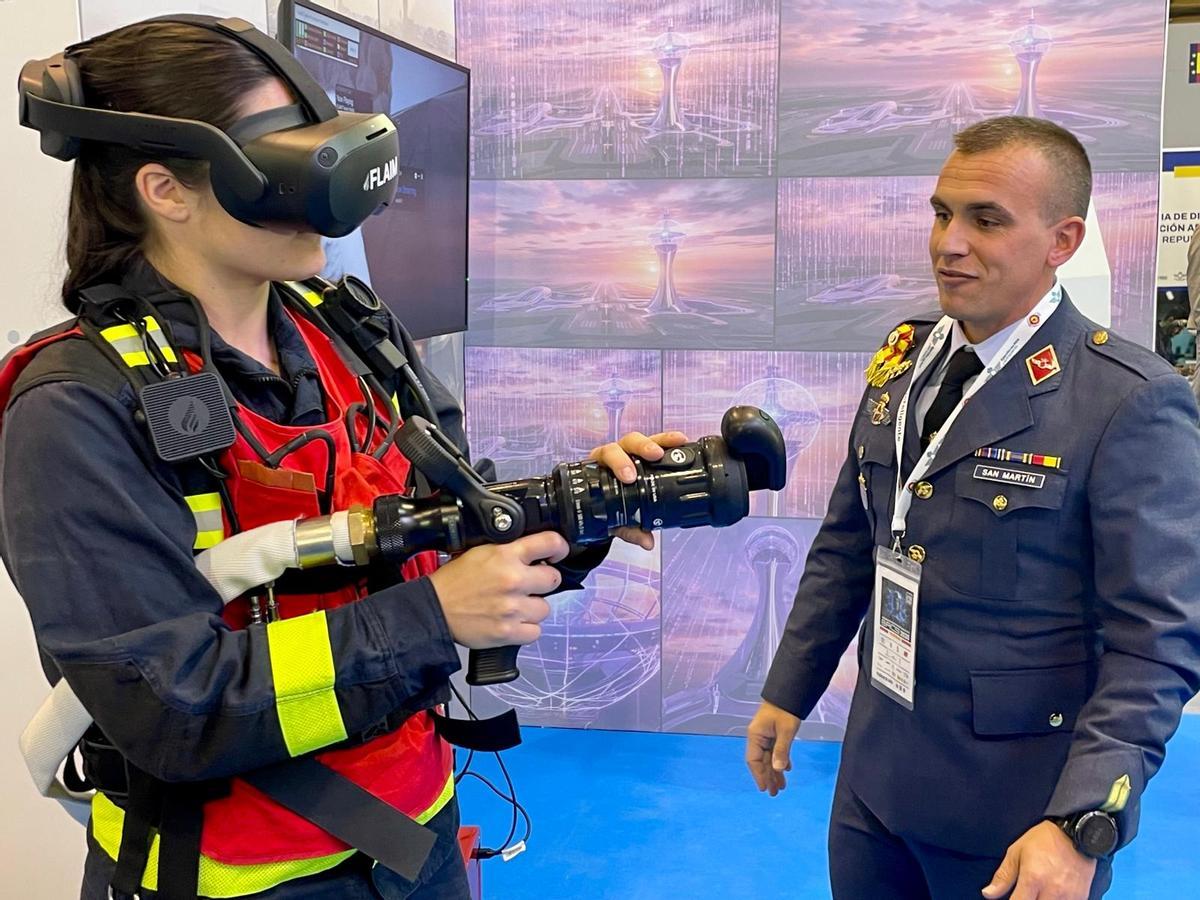 Una soldado bombera y su formador, con un simulador de actuación contra incendios en bases aéreas
