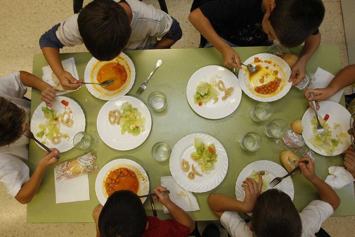 Imagen de archivo de varios niños comiendo en un comedor escolar.