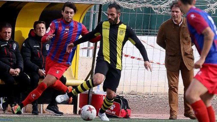 Chema Díaz pugna por un balón ante la mirada de Mullor.