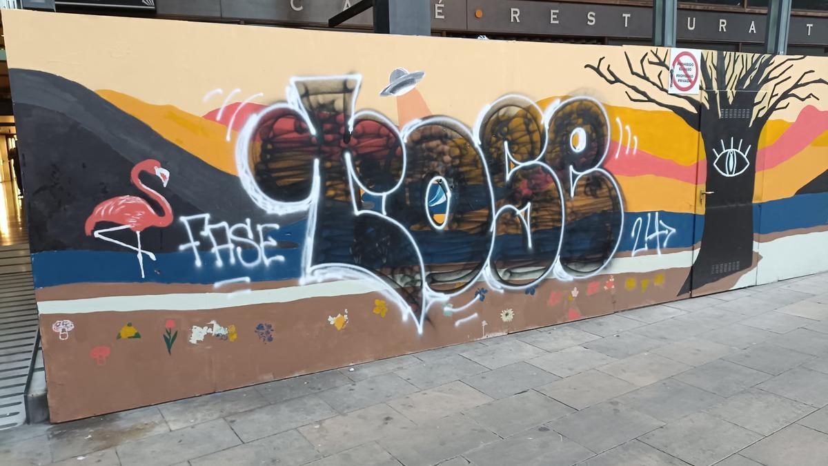 Un grafiti pintado sobre el mural que vecinos y menores del Gòtic dibujaron en la plaza Vila de Madrid, en Barcelona.
