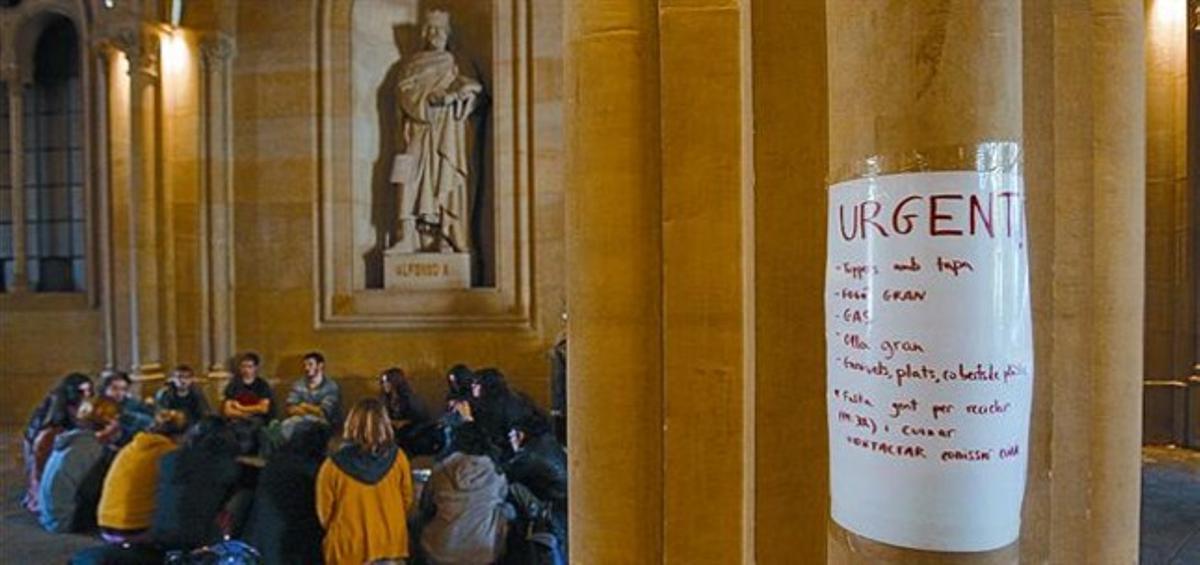 Estudiants sota l’estàtua d’Alfons X de l’edifici central de la Universitat de Barcelona, ahir.