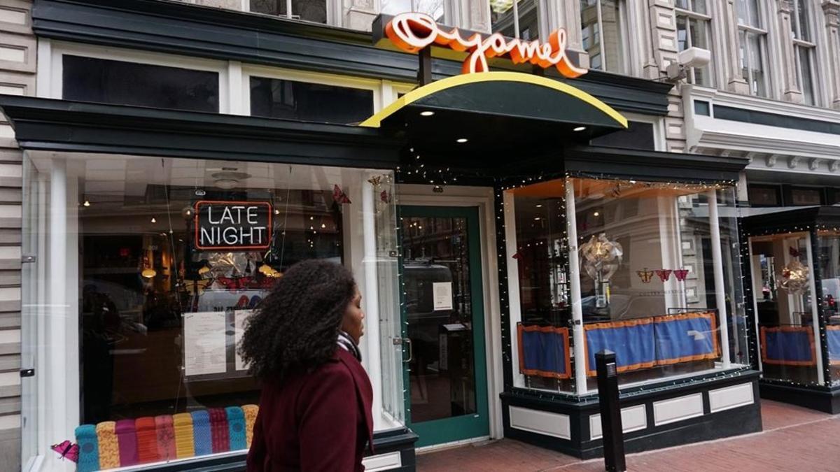 Una mujer pasa junto a un restaurante cerrado por el Día sin Inmigrantes, en Washington, este jueves.