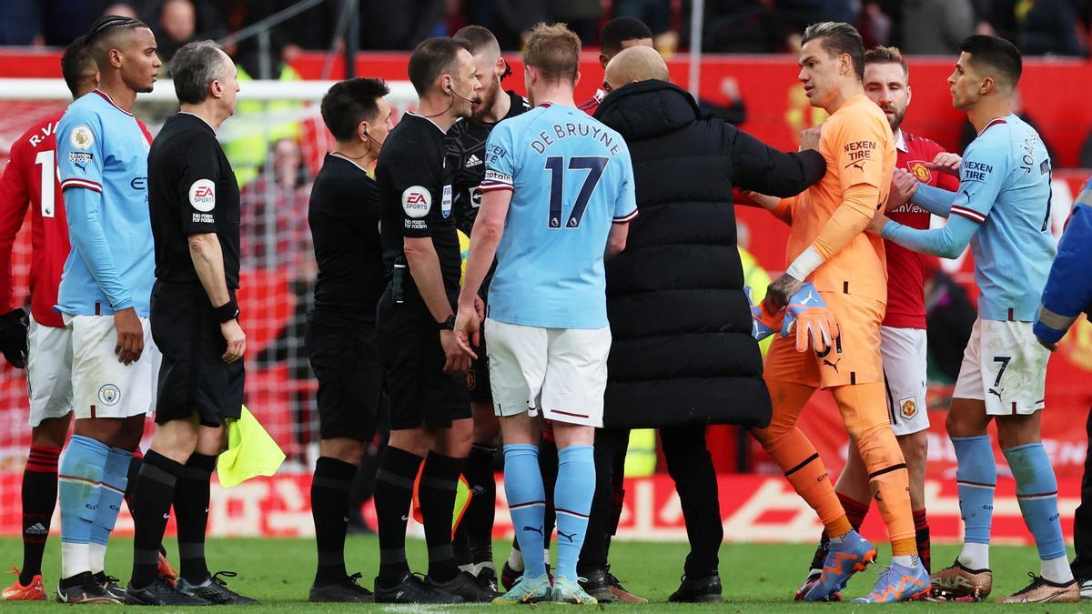 Guardiola protesta al árbitro del derbi de Manchester mientras impide que Ederson se acerque para increparle.