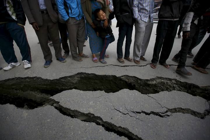 Gente agrupada cerca de una grieta de la carretera tras el terremoto en Katmandú